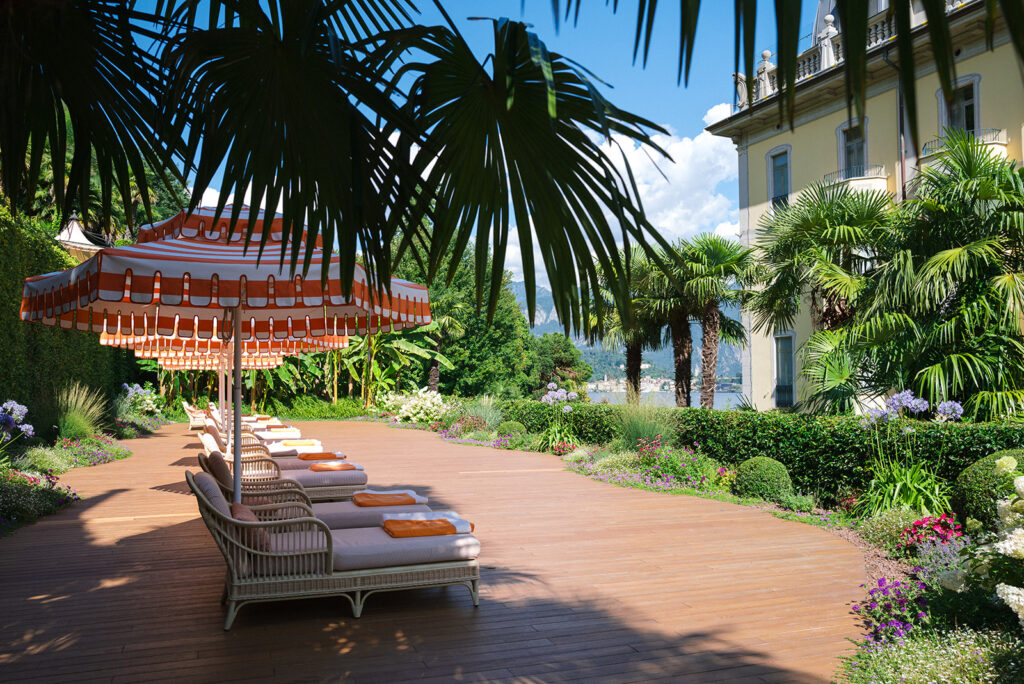 Garden walkway with palms and flowering borders beside the Grand Hotel Tremezzo on Lake Como