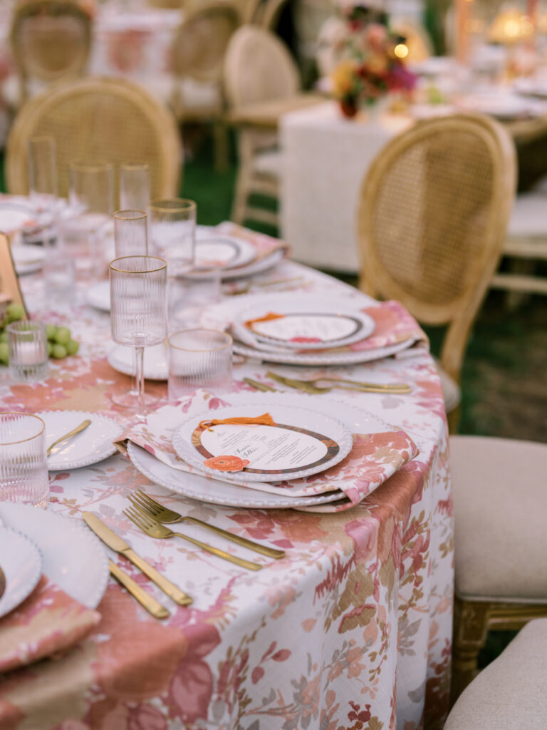 Custom floral table setting with gold flatware and menu card, a detail of luxury wedding planning
