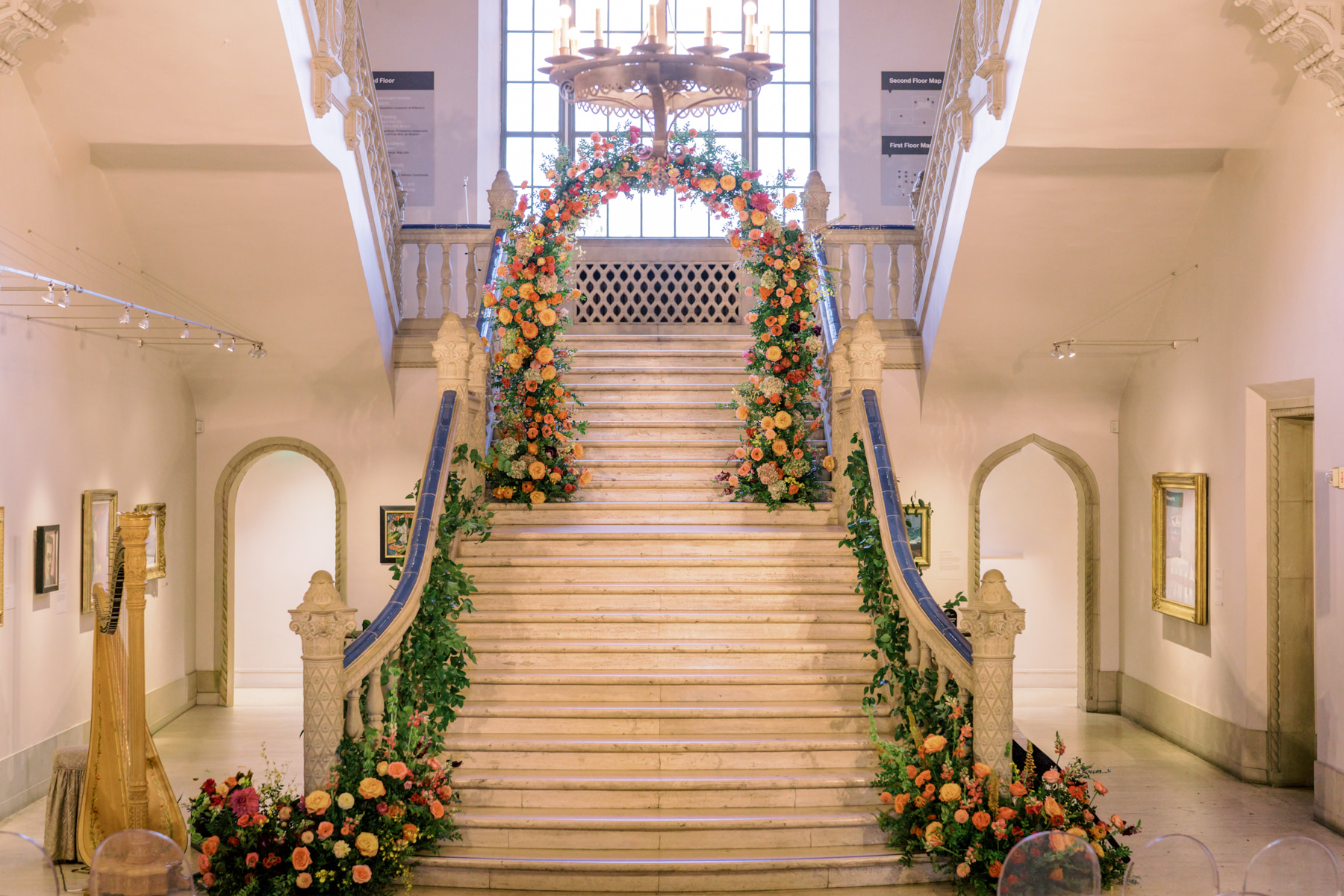 Grand museum staircase dressed in lush floral garlands for a luxury wedding planning ceremony