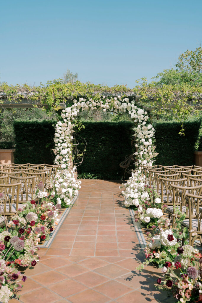 White floral ceremony arch on the Sunrise Patio at Rancho Valencia