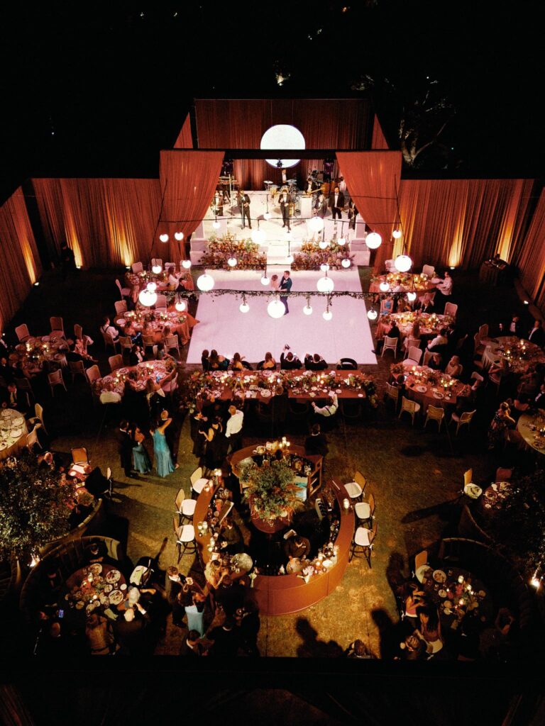 Aerial view of a candlelit evening reception inside a draped structure on the Croquet Lawn at Rancho Valencia